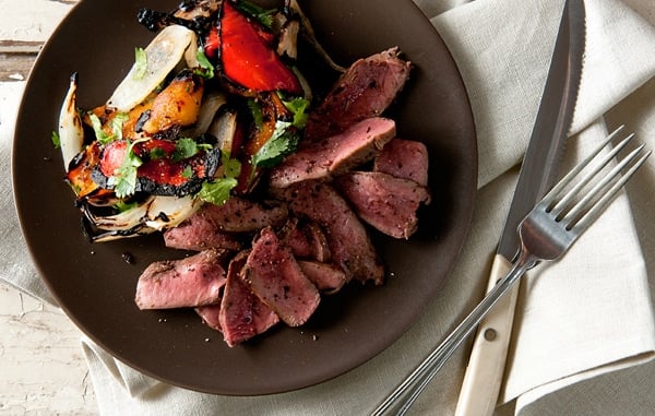 grilled deer heart with peppers on a plate