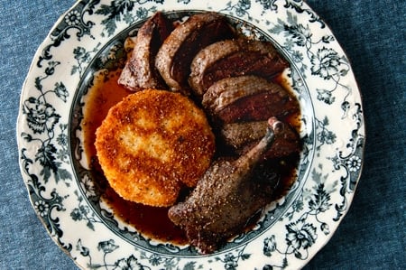 A plate of roast canvasback duck with fried hominy