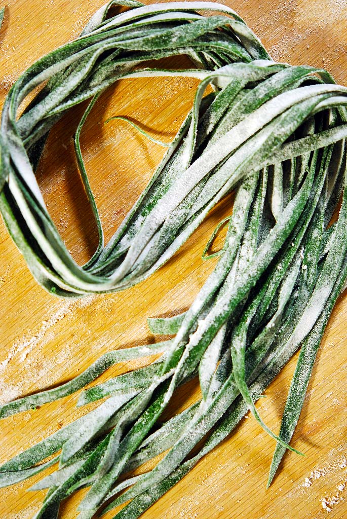 Strettine, nettle pasta on a cutting board. 