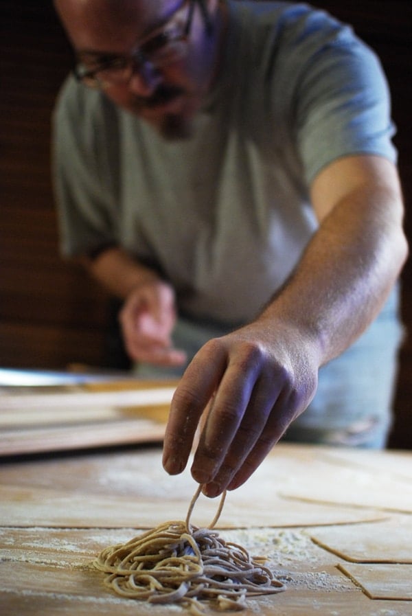 Placing a serving of spaghetti alla chitarra on the cutting board