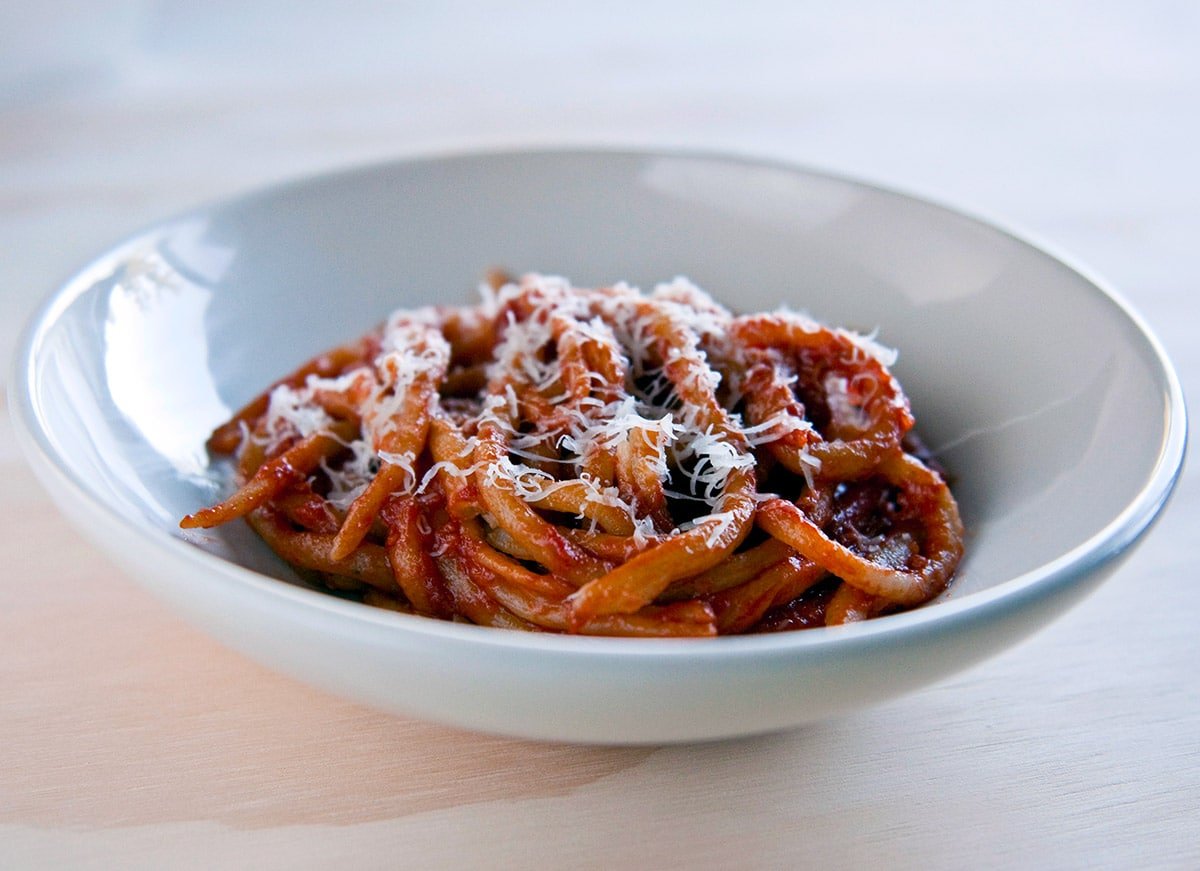 Pici pasta served with fennel tomato sauce in a bowl. 