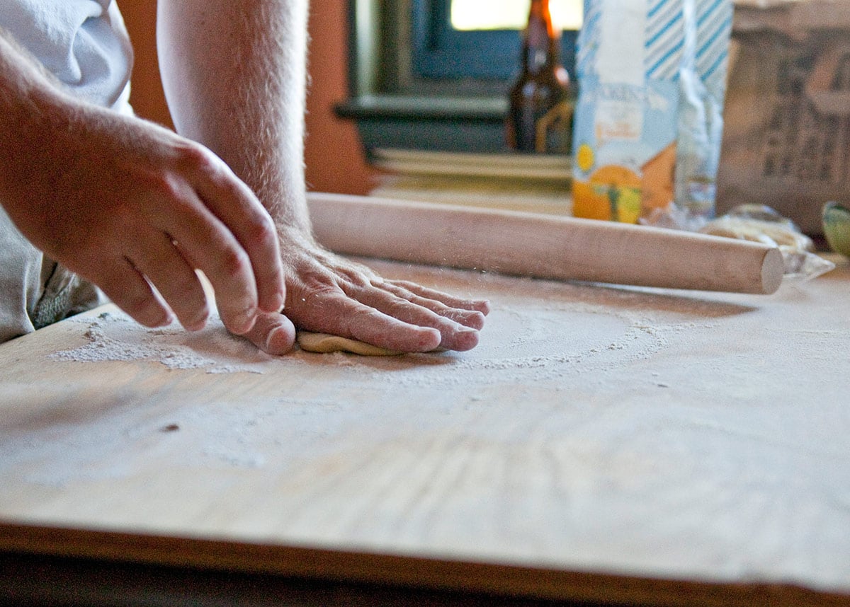 Squashing pasta dough with your hand. 