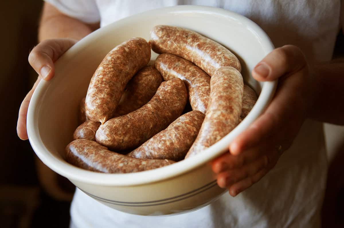 Hank Shaw holding a bowl of freshly made sausages.