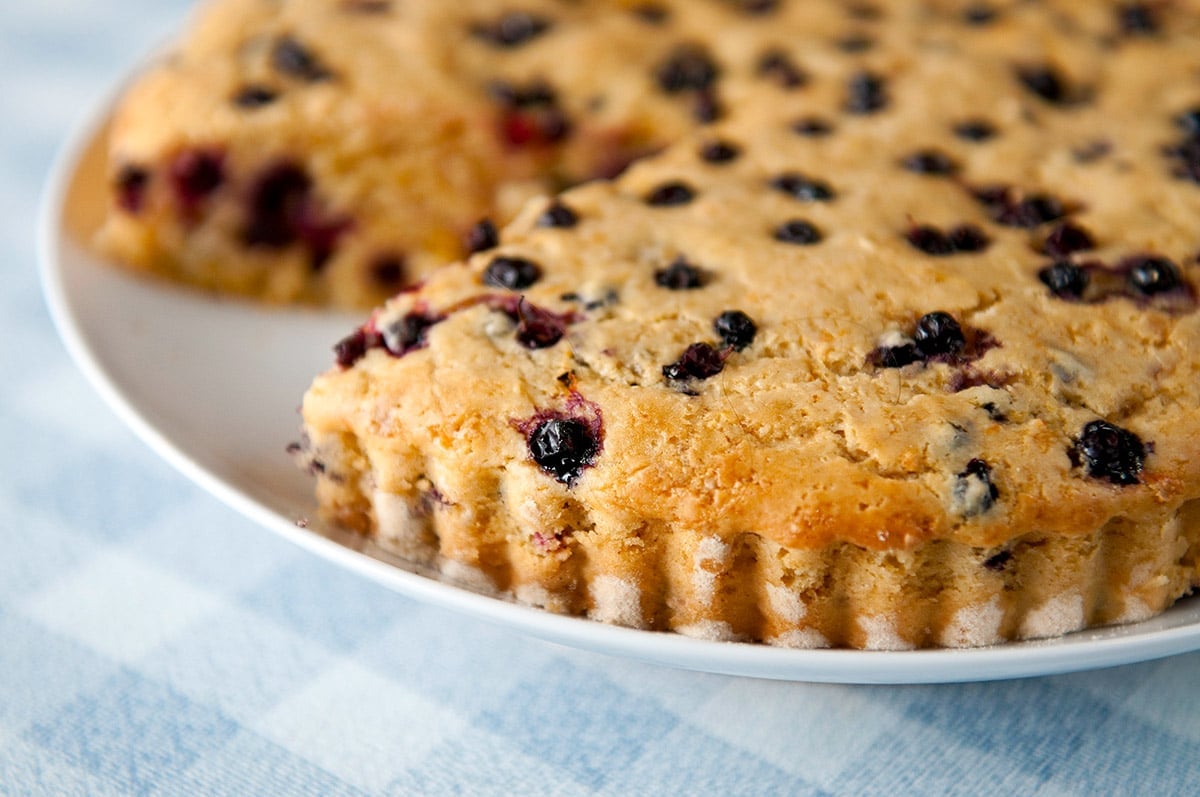 A huckleberry cake with a slice removed. 