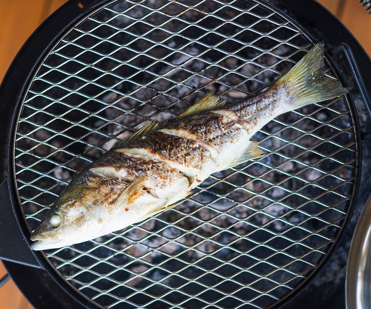 A grilled whole fish over the coals. 