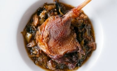 Braised duck legs over a bed of mushrooms and leeks.