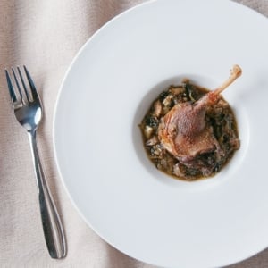 Braised duck legs with leeks, on a fancy plate