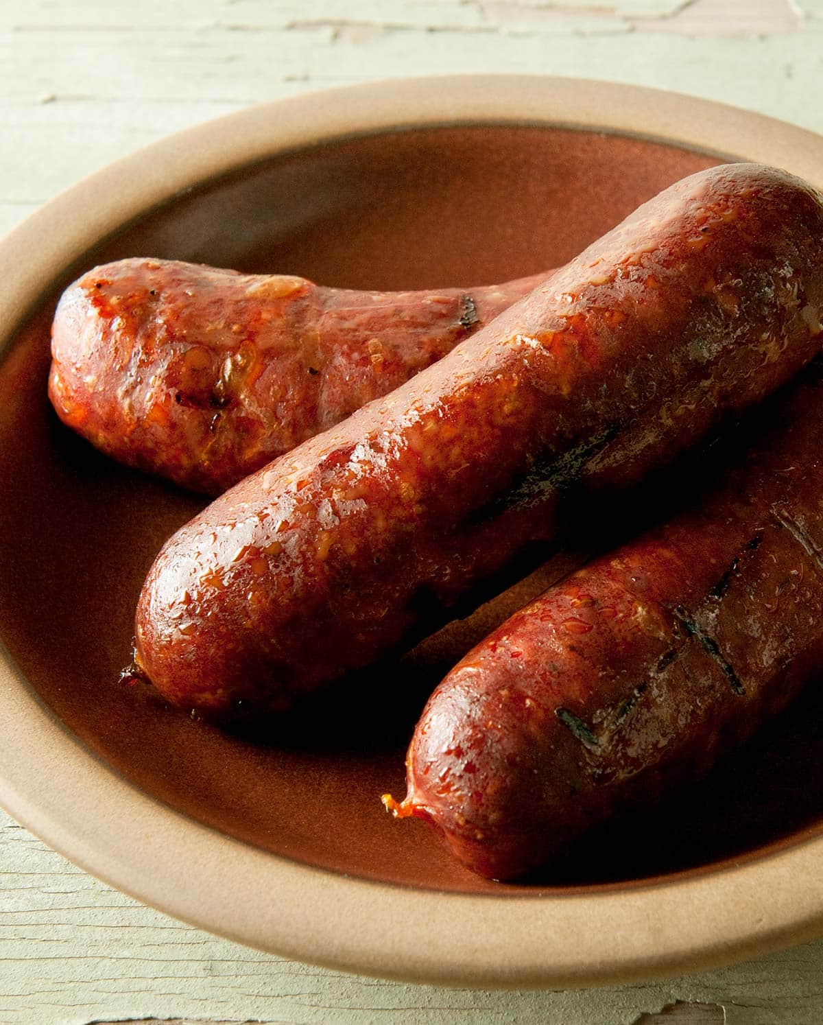 Close up of three links of andouille sausage on a plate. 