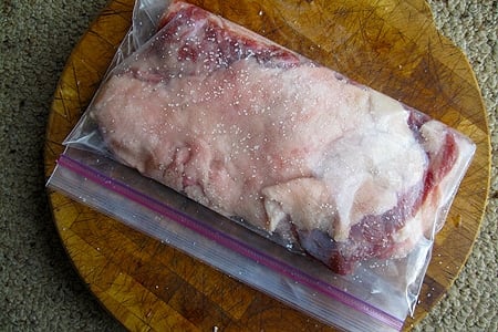Pork belly, salted and in a plastic bag for curing