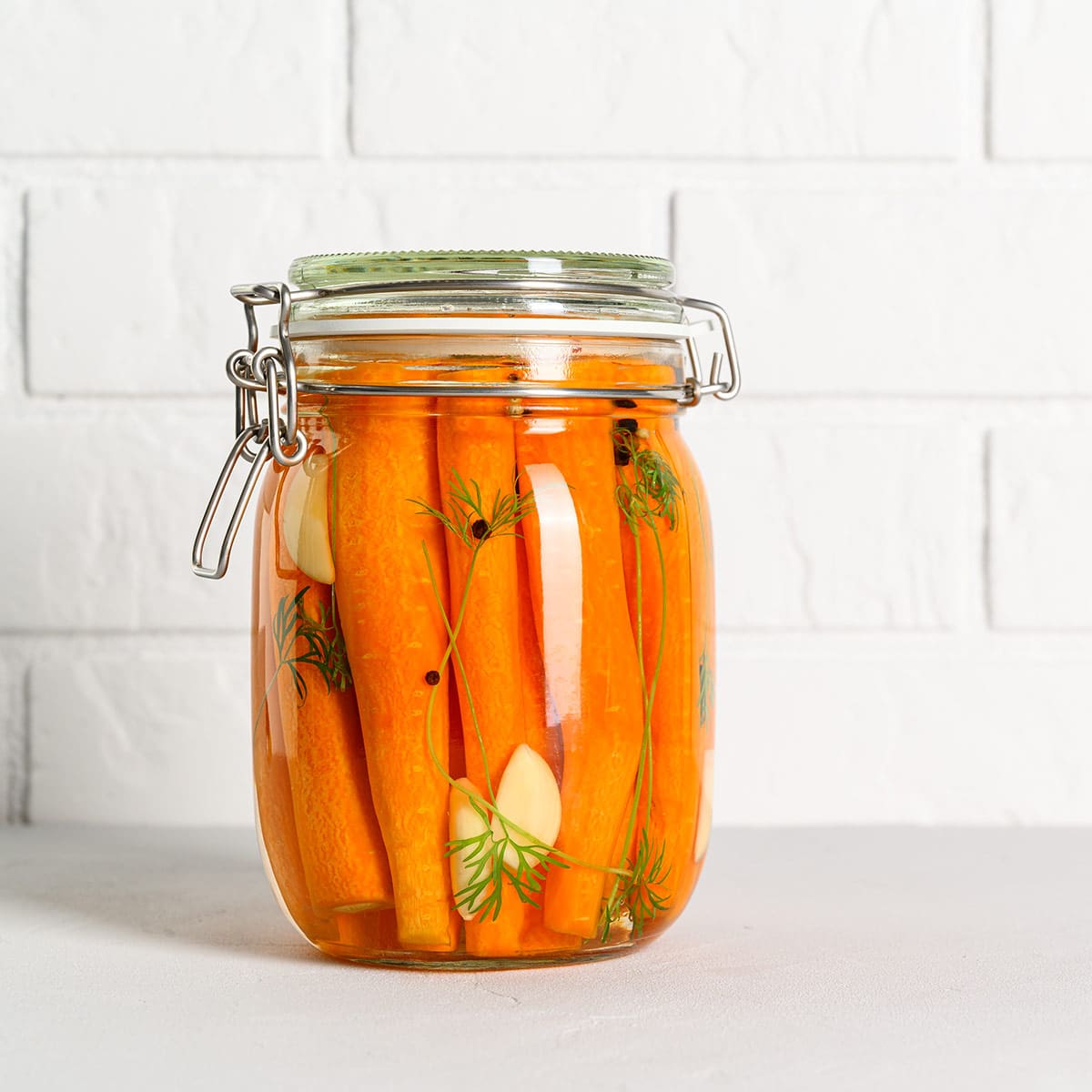 Fermented carrots in a jar on the counter.