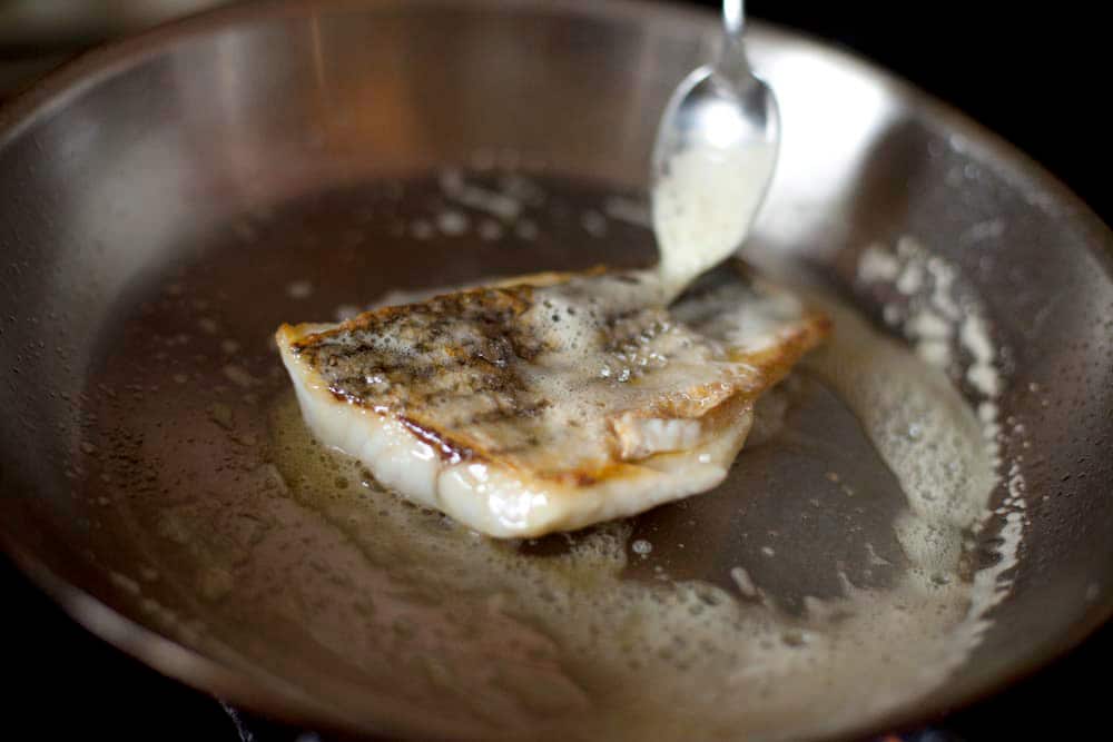 Basting a fish fillet with butter. 