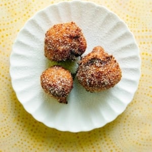 Three elderflower fritters on a plate.