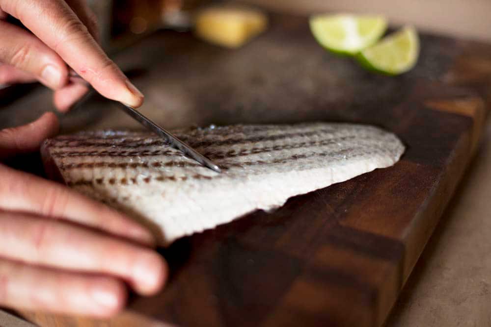 Scraping moisture off the skin of a bass fillet. 