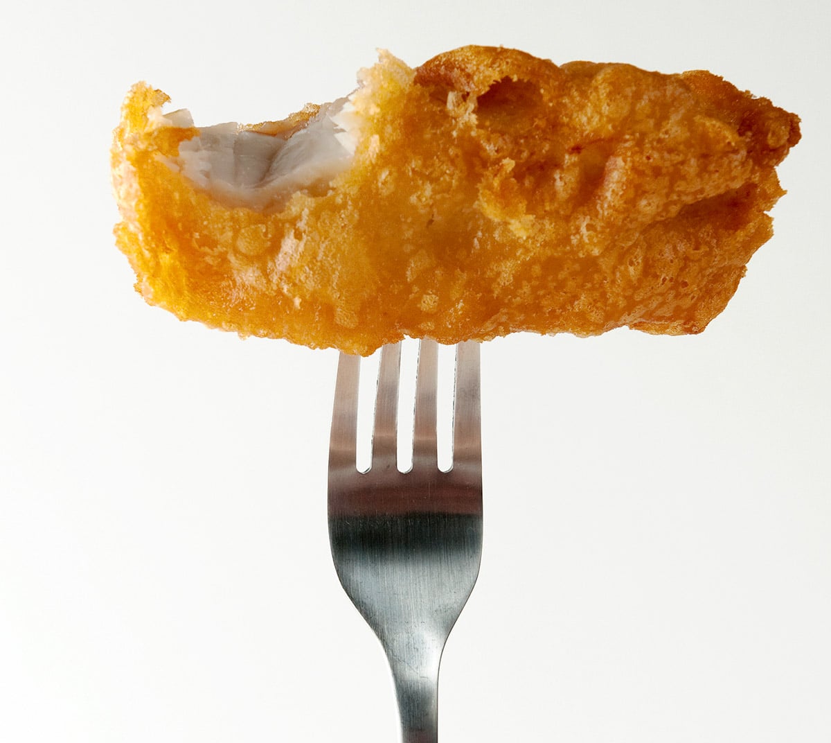 Beer battered fish and chips on a fork