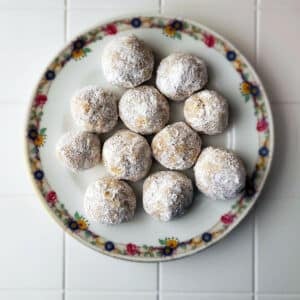 A plate of snowball cookies with walnuts.