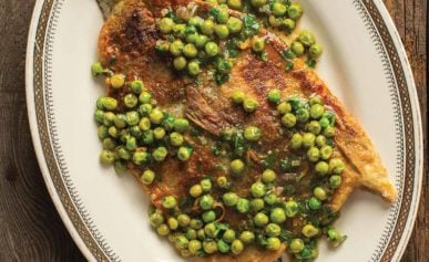 A plate of pan fried trout with peas