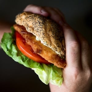 Two hands holding a fried fish sandwich