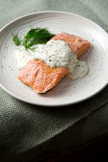 Butter poached salmon with dill sauce on a plate