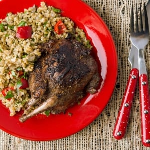 A plate of grilled pigeon with rice pilaf.