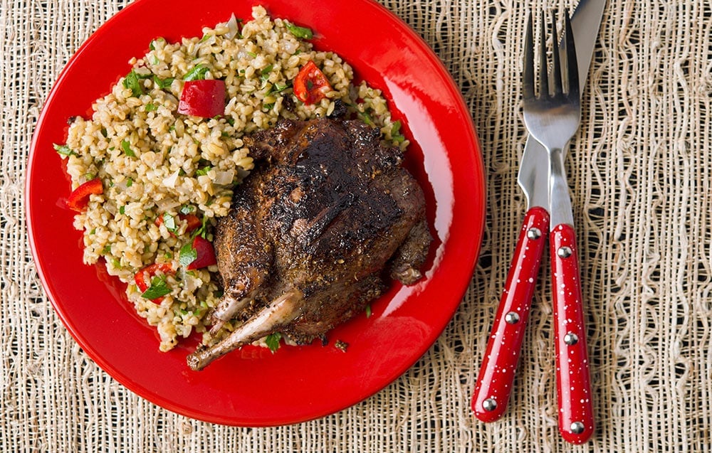 A plate of grilled pigeon with rice pilaf. 