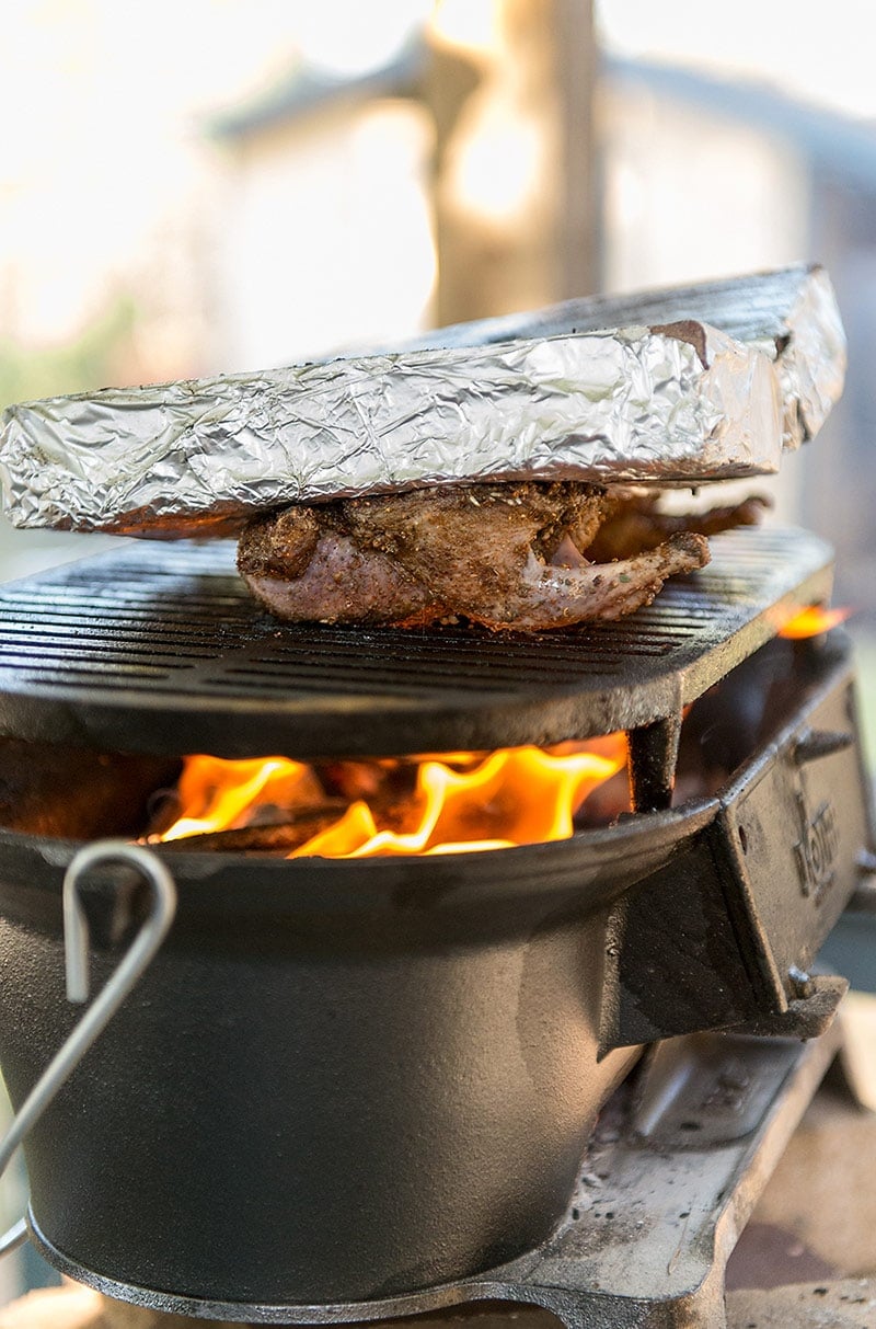 Grilling pigeons under a brick