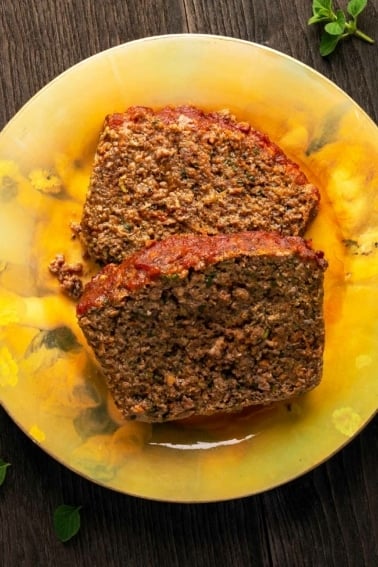 Two slices of venison meatloaf on a plate.