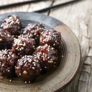 Japanese teriyaki meatballs on a plate with chopsticks