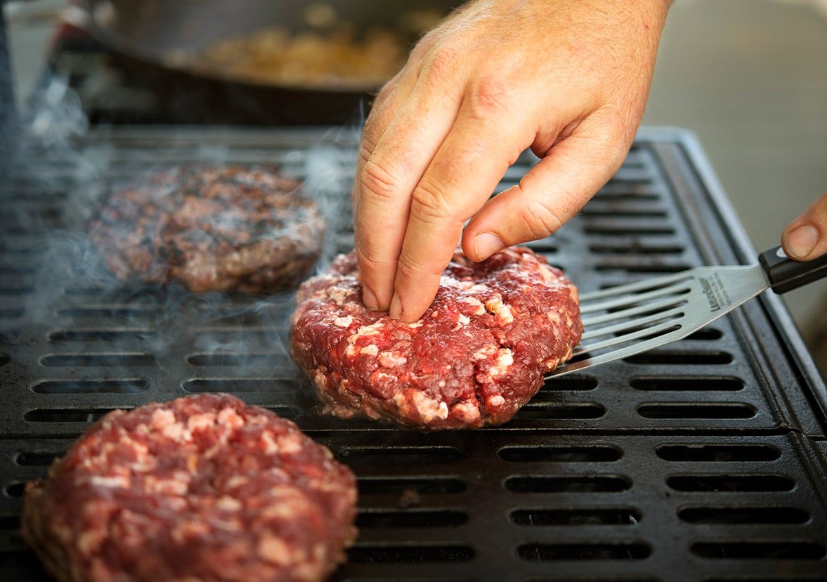 Grilling venison burgers.