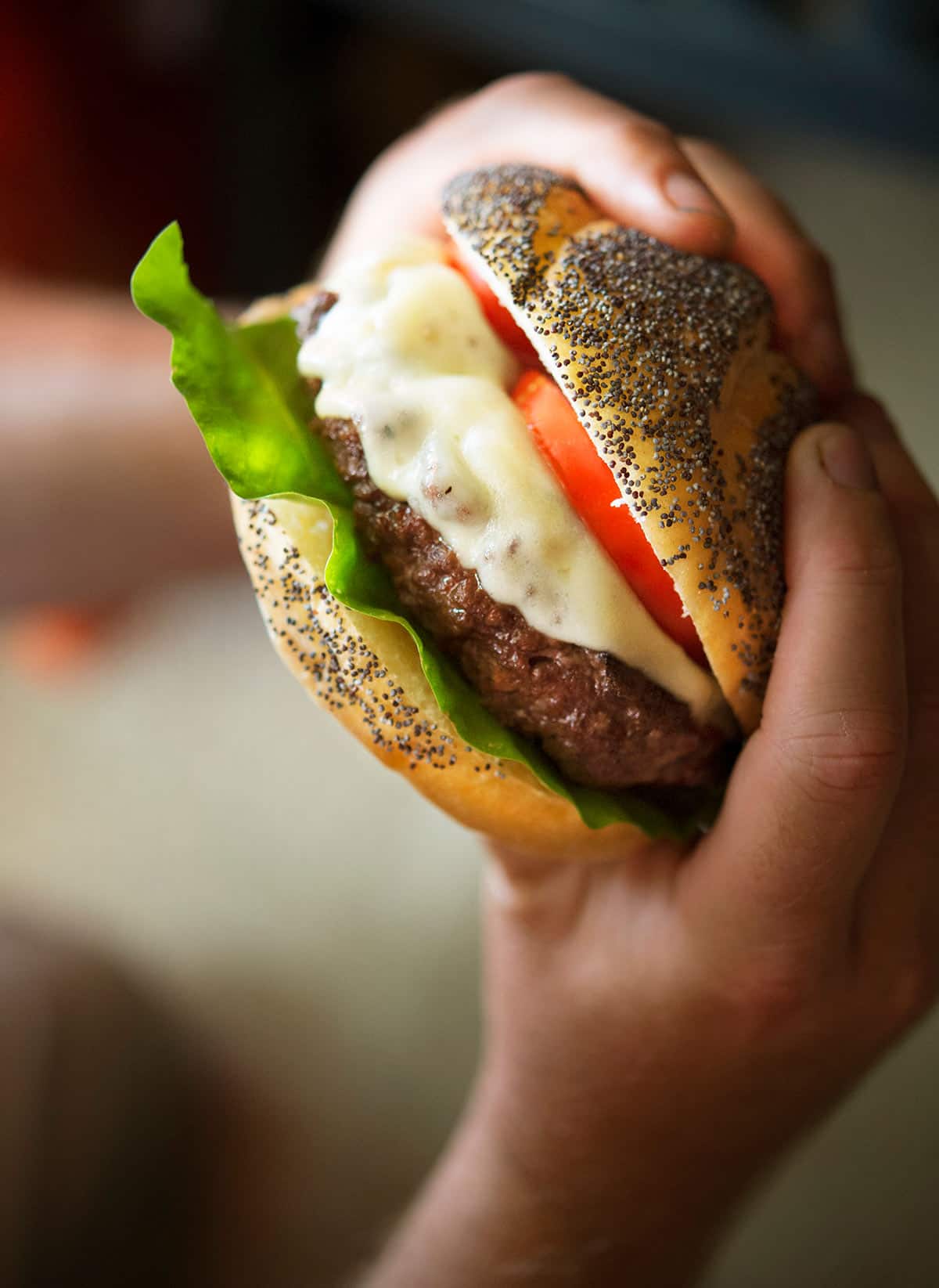 Holding up a venison burger, ready to eat. 