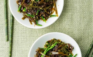 Two plates of Japanese seaweed salad with chopsticks.