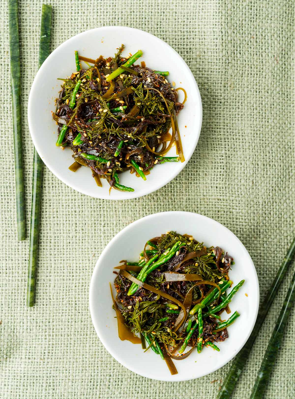 Two plates of Japanese seaweed salad with chopsticks. 