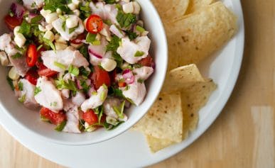 A bowl of ceviche with tortilla chips.