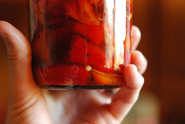 holding a jar of preserved peppers