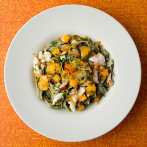 A bowl of kelp pasta with fish and summer vegetables.