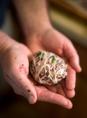 Holding a meatball wrapped in caul fat