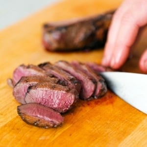 Finished duck breasts recipe on a cutting board.