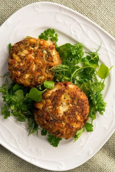 Finished fish cakes recipe on a plate with a green salad.