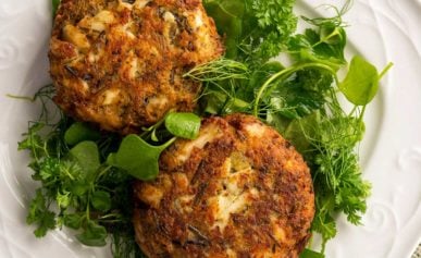 Finished fish cakes recipe on a plate with a green salad.