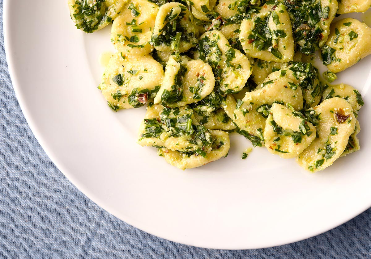 A plate of arugula pesto with pasta.