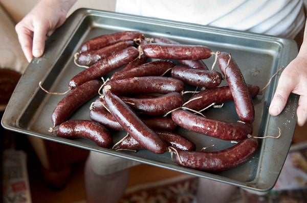 holding a tray of venison landjaeger 