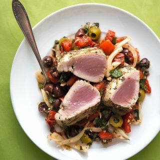 Gegrillte Thunfischsteaks mit sizilianischem Salat auf einem Teller