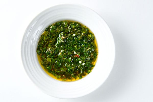 A bowl of chimichurri sauce. 