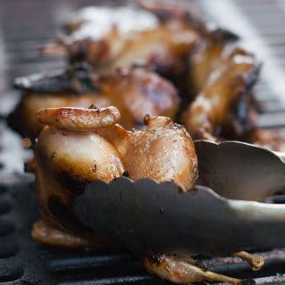 Turning a grilled quail.