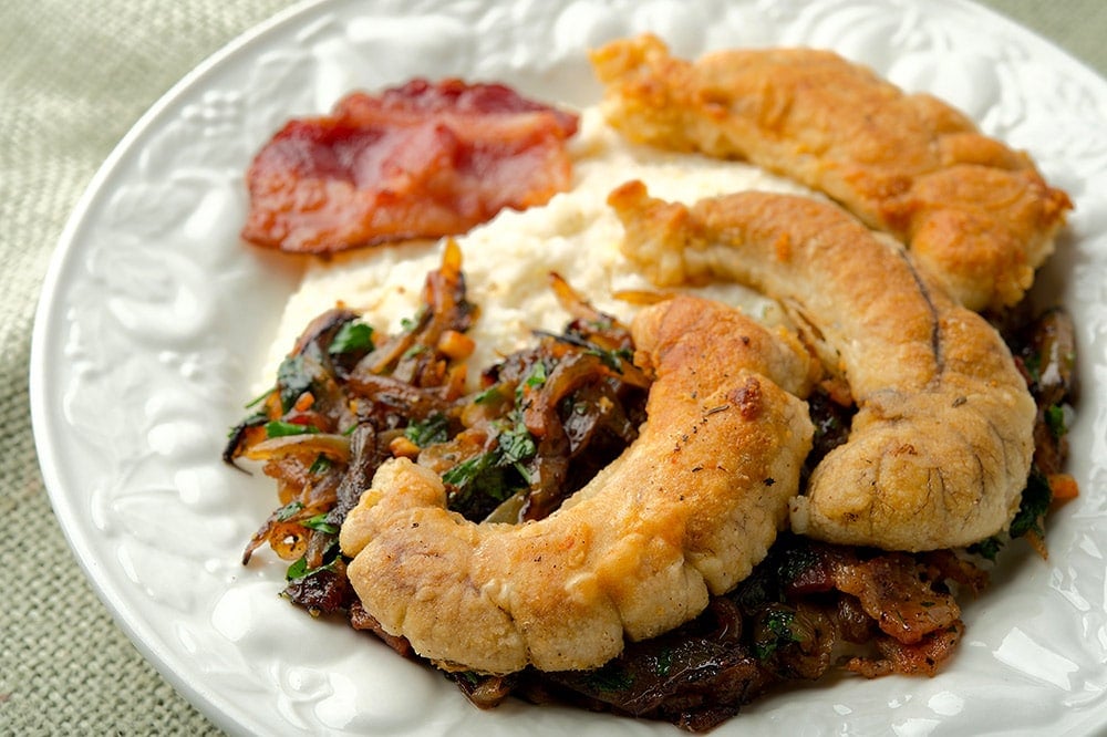 shad roe with bacon and grits on a plate