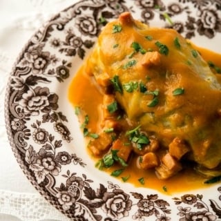 Chou farci, stuffed cabbage, on a plate with a tomato sauce.