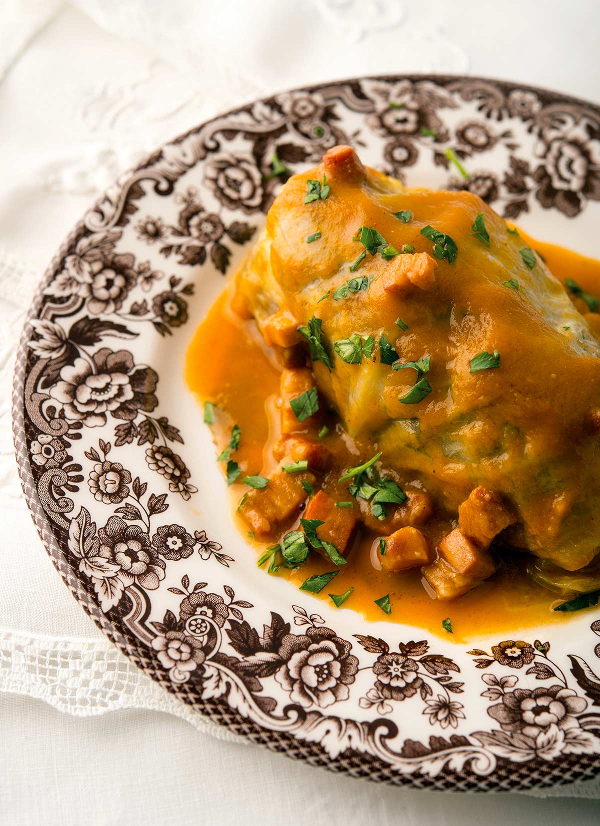 Chou farci, stuffed cabbage, on a plate with a tomato sauce. 