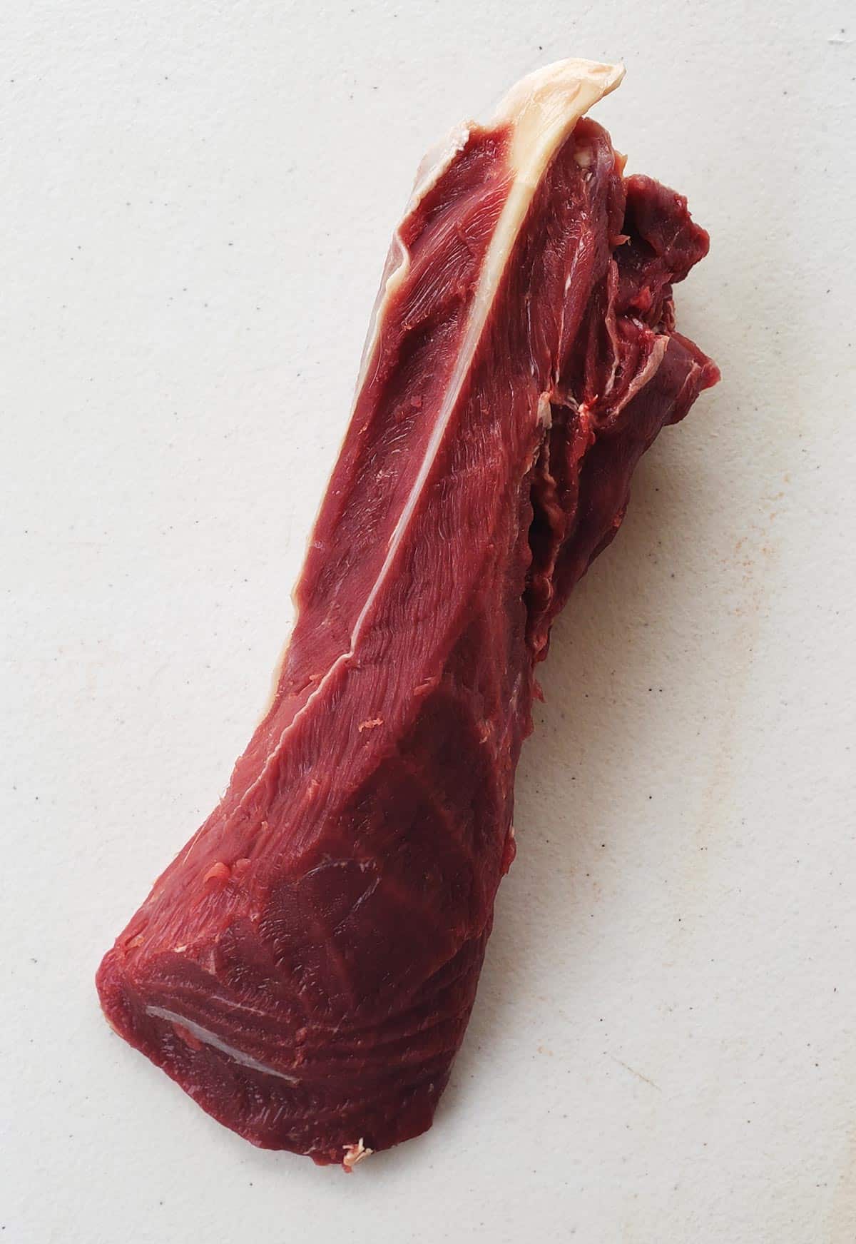 Blade roast showing sinew between two flat iron steaks. 