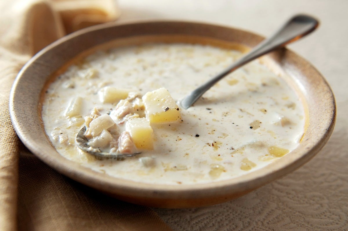 A bowl of Maine clam chowder, showing the potatoes and clams. 