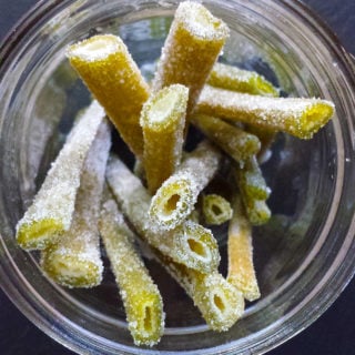 Stalks of candied angelica in a glass jar.