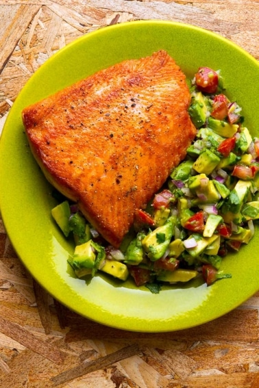 Seared salmon with avocado salsa on a plate